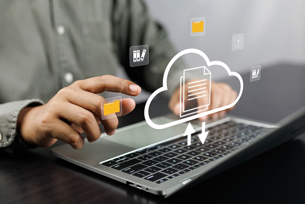 A businessman on a laptop showcasing a cloud-based documentation