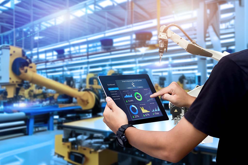 A person holding a tablet looking at analytics in a factory