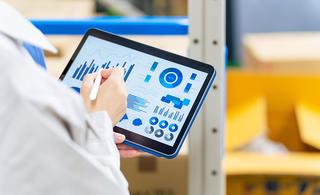 A worker checking inventory on a tablet in a warehouse